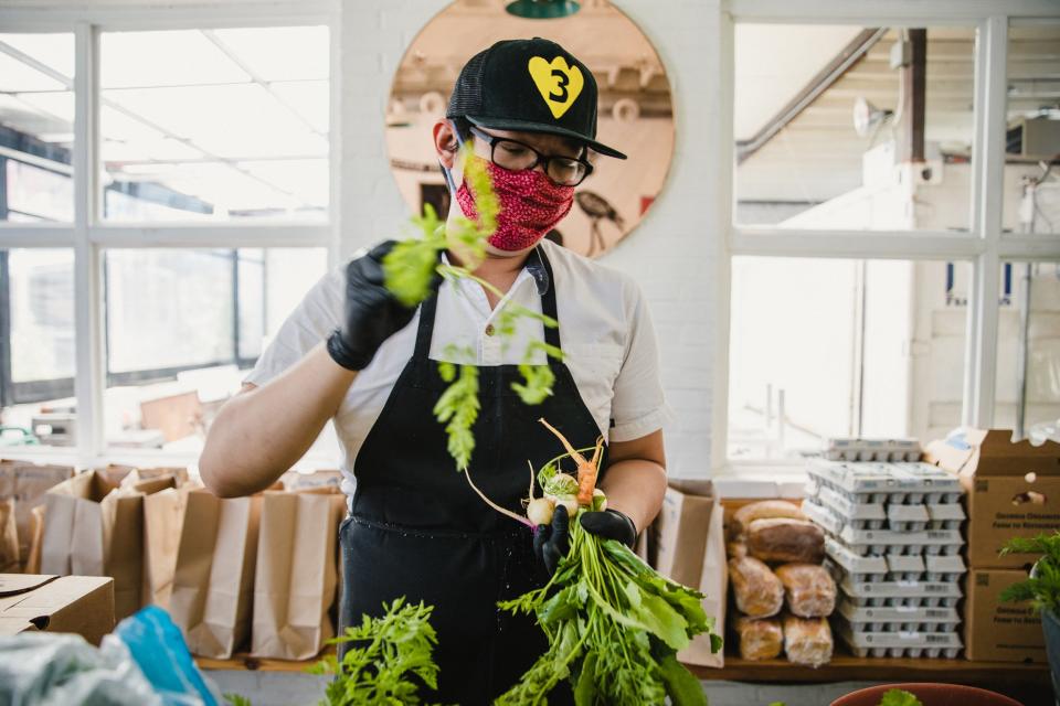 8Arm sous chef Duy Huynh bundles vegetables from local farms for a CSA program the restaurant is running in lieu of regular food and drink service.