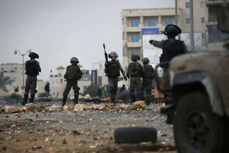 Israeli security forces hold a position during clashes with Palestinian stone throwers in Beit El on October 7, 2015