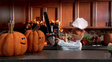 The Muppet Swedish Chef is in a kitchen with a chainsaw aimed at two animated pumpkins. The pumpkins appear startled