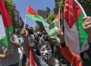 A Palestinian youth wears a Guy Fawkes mask at an anti-Israel demonstration during a general strike, in the West Bank city of Ramallah, Tuesday, May 18, 2021. Palestinians across Israel and the occupied territories are on strike in a rare collective action against Israel’s policies, as the war, now in its second week, showed no signs of abating. (AP Photo/Nasser Nasser)