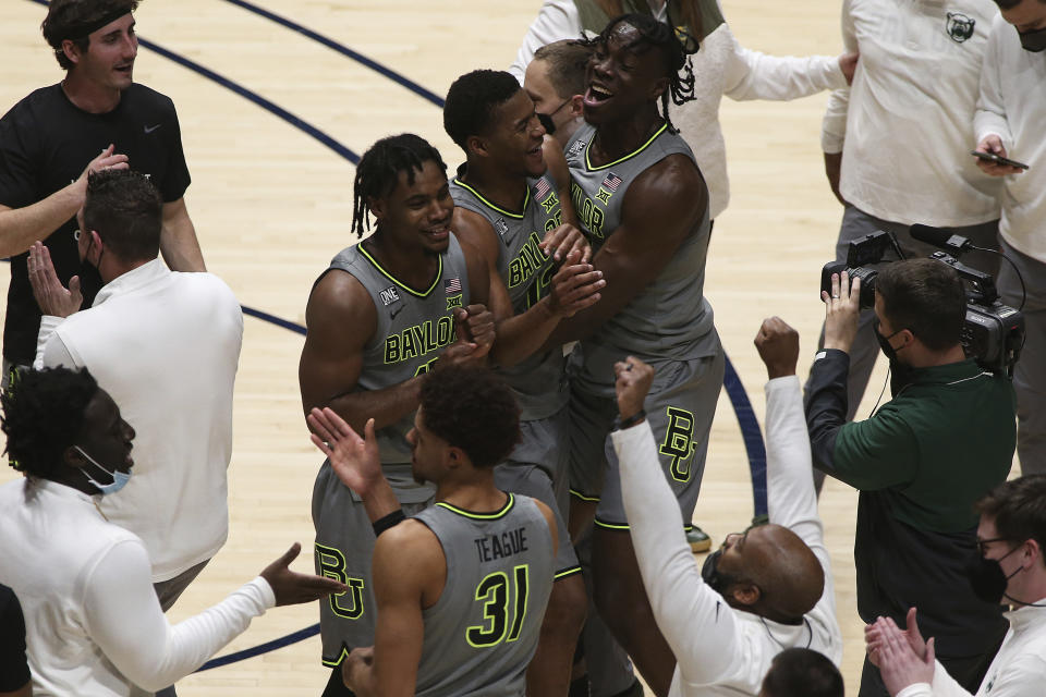 Baylor players celebrate on the court after an overtime win against West Virginia in an NCAA college basketball game Tuesday, March 2, 2021, in Morgantown, W.Va. (AP Photo/Kathleen Batten)