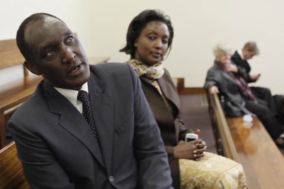 FILE - In this Thursday July 12, 2012 file photo, Rwandan exile Kayumba Nyamwasa, left, and his wife Rosette Kayumba, sit in a Johannesburg court after finishing his testimony as a witness in the trial of six East Africans accused of attempted murder in his 2010 shooting. Critics of Rwanda's government say the killing in South Africa in early Jan. 2014 of prominent Rwandan dissident Patrick Karegeya is another sign of an increasingly violent power struggle among the country's Tutsi elite who have held power since 1994. (AP Photo/Denis Farrell, File)