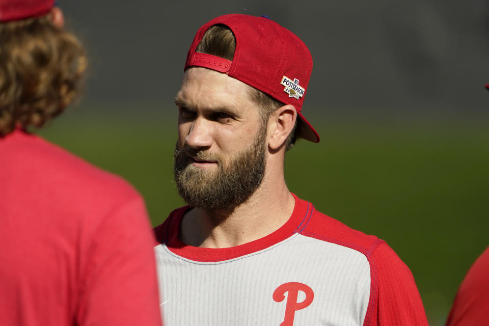 Philadelphia Phillies' Bryce Harper talks with teammates during baseball practice Thursday, Oct. 6, 2022, in St. Louis. The Phillies and St. Louis Cardinals are set to play Game 1 of a National League Wild Card baseball playoff series on Friday in St. Louis. (AP Photo/Jeff Roberson)