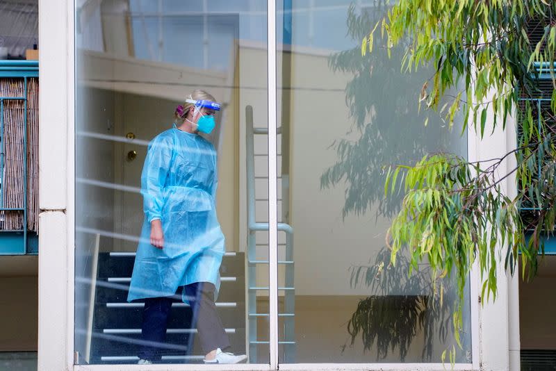 A healthcare worker walks down stairs at a complex locked down during a COVID-19 outbreak in Melbourne