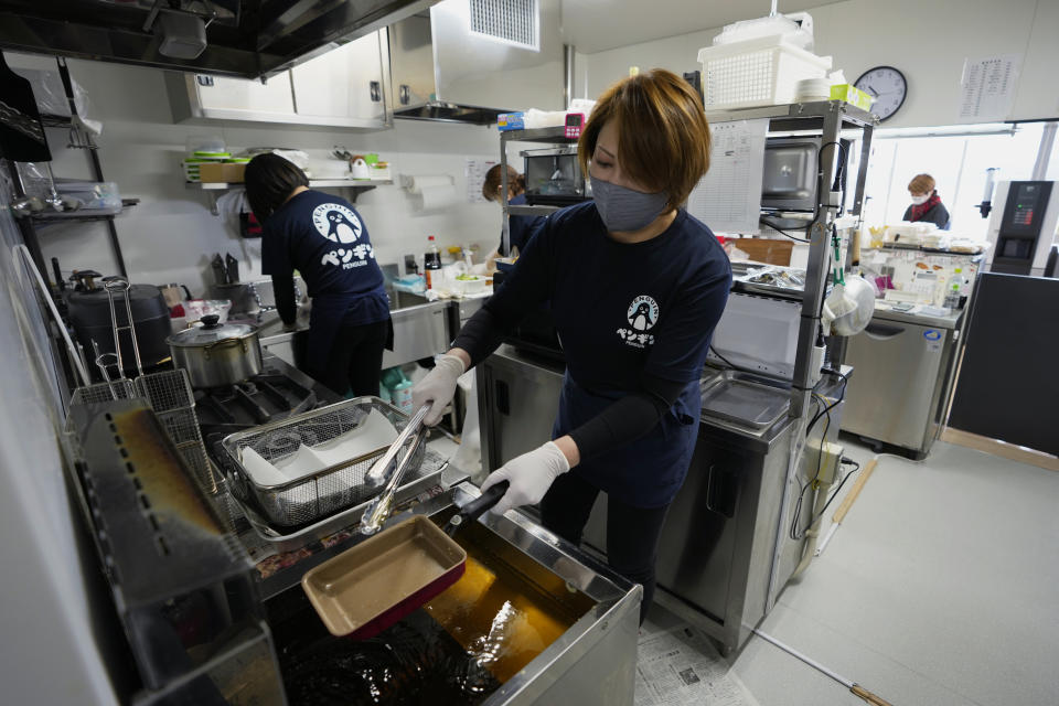 Fast-food restaurant owner Atsuko Yamamoto leads her crew at her shop, Penguin, in Futaba Business Incubation and Community Center in Futaba town, northeastern Japan, Wednesday, March 2, 2022. Yamamoto restarted Penguin, one of her family's old businesses, in 2020, when the community center opened for the public, as she wanted to help bring local people back together, as part of her way of the area reconstruction, following the 2011 earthquake. (AP Photo/Hiro Komae)