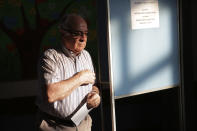 A man leaves a voting booth carrying his ballot paper at a polling station in Lisbon Sunday, Oct. 6, 2019. Portugal is holding a general election Sunday in which voters will choose members of the next Portuguese parliament. (AP Photo/Armando Franca)