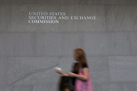 A woman walks through the lobby of the U.S. Securities and Exchange Commission headquarters in Washington, in this file photo taken June 24, 2011. REUTERS/Jonathan Ernst/Files