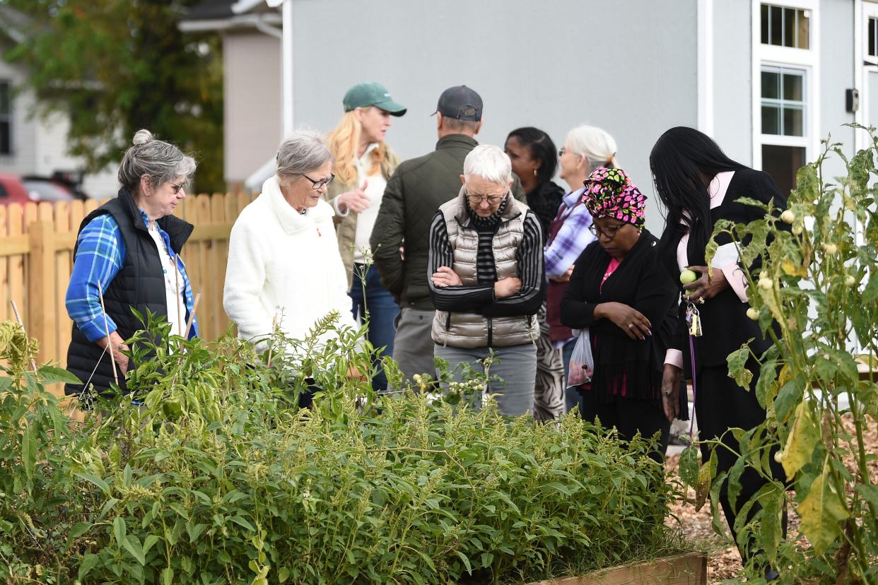 People tour the community garden at Payne Avenue Missionary Baptist Church after the ribbon cutting.