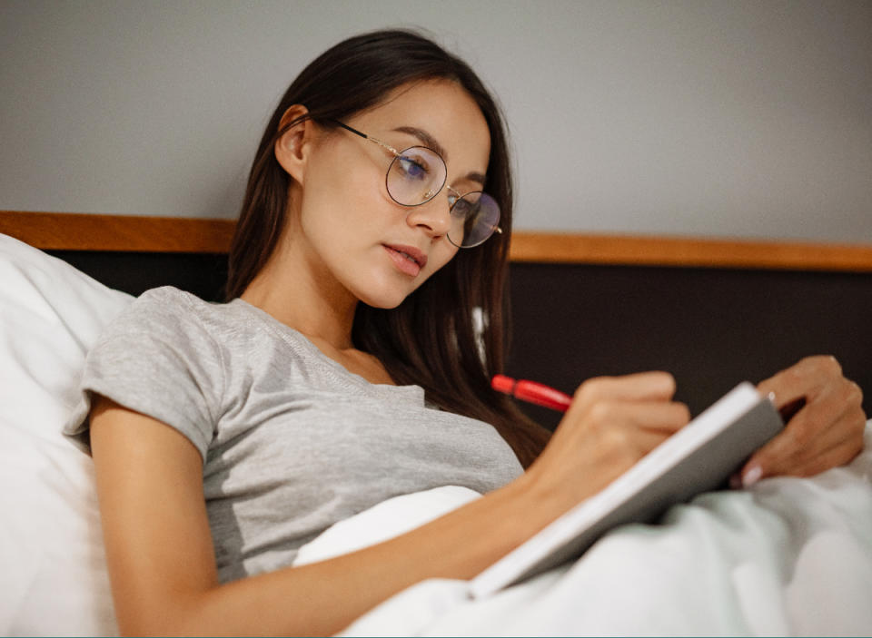 woman journaling in bed before going to sleep