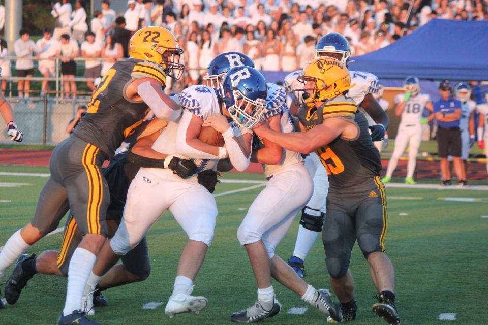 Rochester Adams’ Brady Prieskorn and Liam Kania bottle up Rochester quarterback Ethan Bieniasz and bring him down for a loss late in the first half of the cross-town battle played at Adams on Sept. 1.