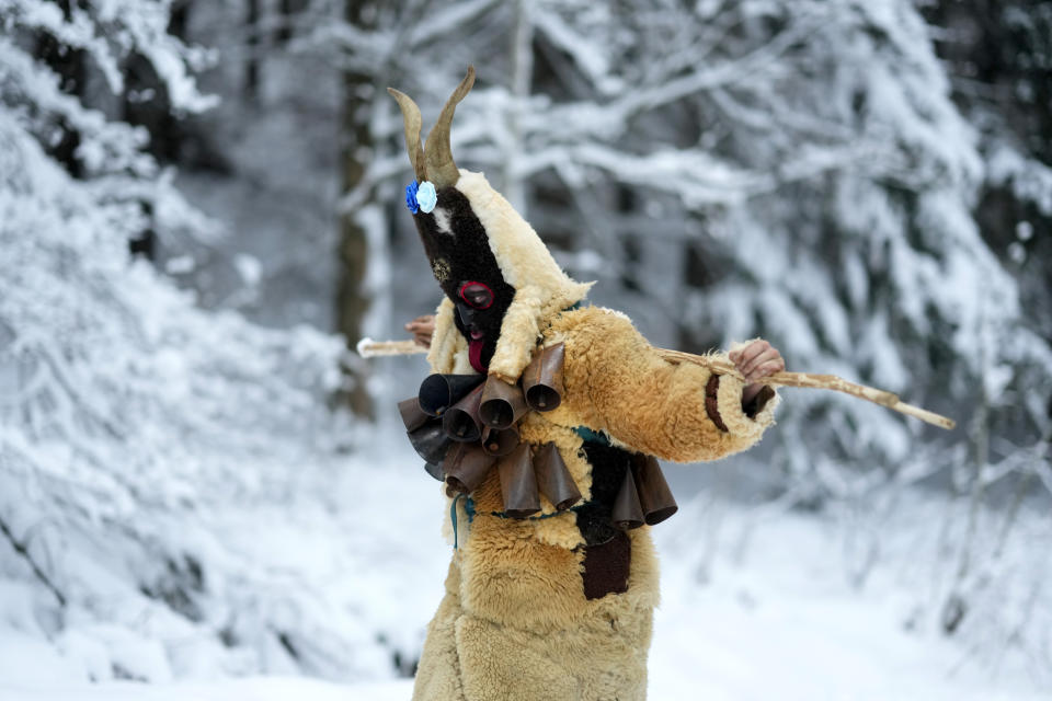 A reveler depicting the devil holds a stick during a traditional St. Nicholas procession near the village of Lidecko, Czech Republic, Sunday, Dec. 3, 2023. This pre-Christmas tradition has survived for centuries in a few villages in the eastern part of the country. (AP Photo/Petr David Josek)