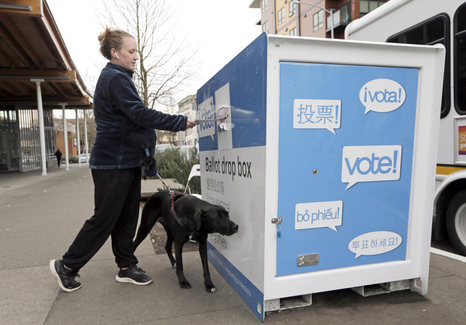 Matilda Jagger with her dog Basil drops off a ballot in the Washington State primary on March 10, 2020 in Seattle.  (John Froschauer/AP)