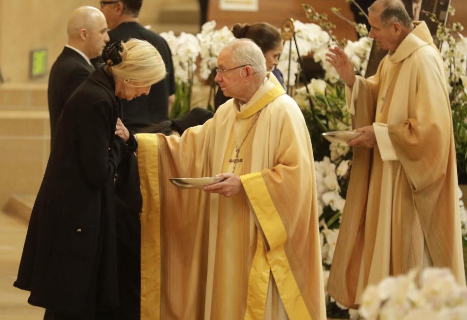 Elizabeth Riordan, left, wife of Mayor Richard Riordan, receives a blessing from Archbishop Jose H. Gomez