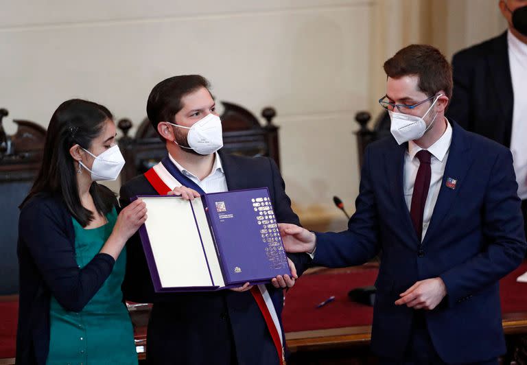 La presidenta y el vicepresidente de la Convención Constitucional chilena María Elisa Quinteros (izq.) y Gaspar Domínguez (der.) respectivamente, entregan el borrador final de la propuesta constitucional al presidente chileno Gabriel Boric, durante su presentación en el Congreso Nacional en Santiago, el 4 de julio de 2022.