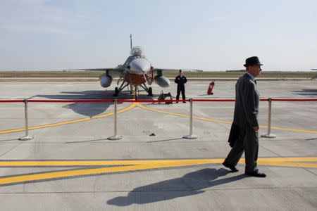 A man walks in front of an F-16 plane that is on display at the 86th Air Base of Romanian Air Force during the official presentation ceremony of 6 F-16 planes bought by the Romanian government, in Fetesti, Calarasi county, Romania October 7, 2016. Inquam Photos/Octav Ganea/via REUTERS