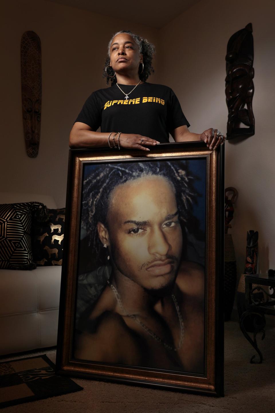 Ka-Nekia Hughes displays a large framed photograph of her son Sylvester Jenkins who was among Jacksonville's homicide victims in 2022.