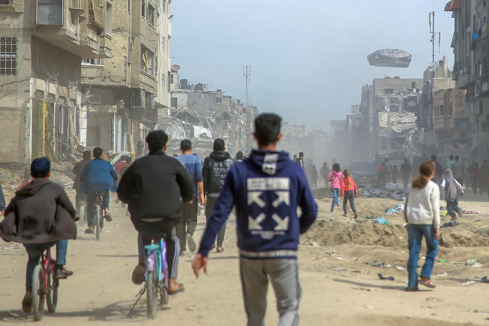 Palestinians watch as humanitarian aid is airdropped into Gaza City on Friday.