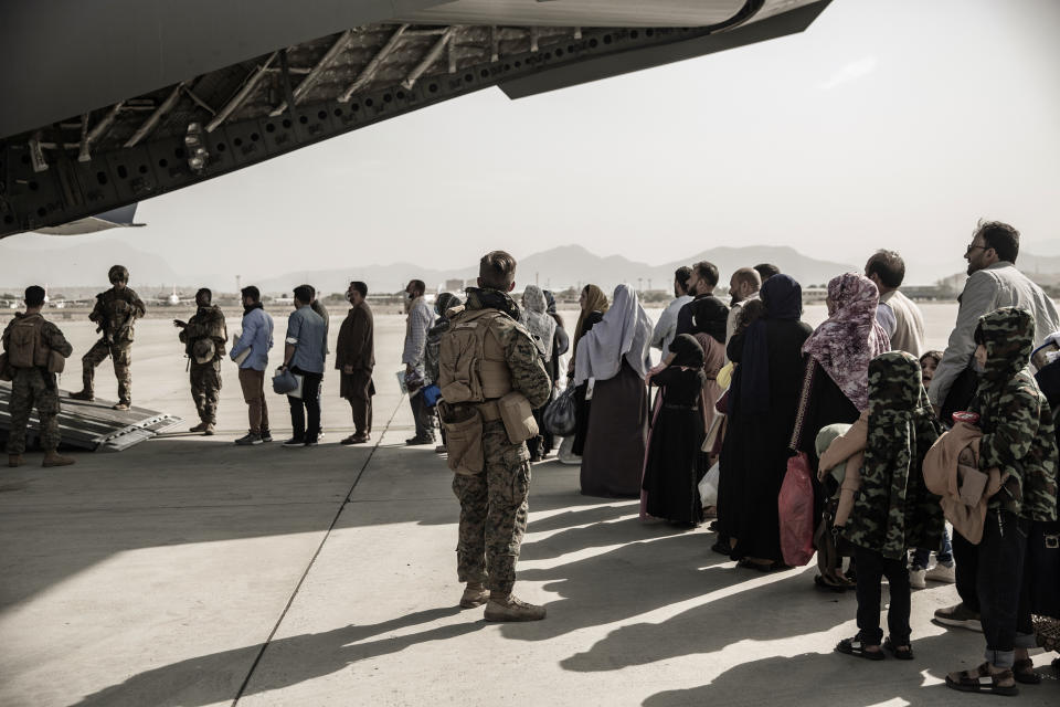 In this image provided by the U.S. Marine Corps, evacuees wait to board a Boeing C-17 Globemaster III during an evacuation at Hamid Karzai International Airport in Kabul, Afghanistan, Monday, Aug. 30. 2021. (Staff Sgt. Victor Mancilla/U.S. Marine Corps via AP)