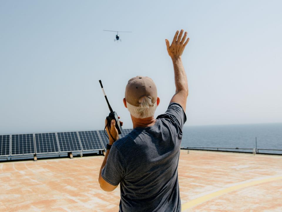 Richard Neal, executive director of Frying Pan Tower Inc., waves in a helicopter delivering Amazon packages.