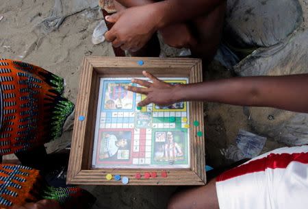Children play a board game on the beach in the township of West Point, in Monrovia, Liberia, October 18, 2017. Picture taken October 18, 2017. REUTERS/Thierry Gouegnon