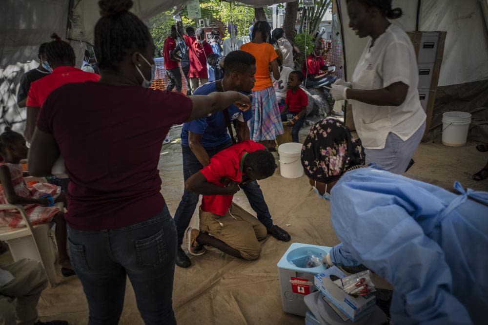 A youth suffering from cholera symptoms is helped upon arrival at a clinic run by Doctors Without Borders in Port-au-Prince, Haiti, Thursday, Oct. 27, 2022. (AP Photo/Ramon Espinosa)