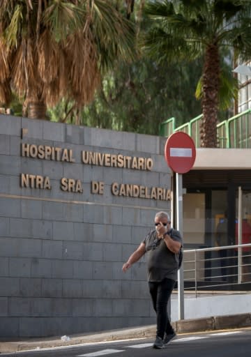 A man wearing a mask walks past Nuestra Senora de Candelaria University Hospital in Santa Cruz de Tenerife, where an Italian national has been isolated after testing positive for the novel coronavirus