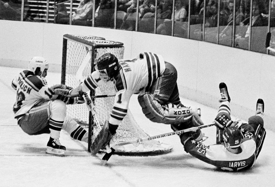 FILE - In this Dec. 7, 1983, file photo, Washington Capitals' Doug Jarvis (25), right, scores a goal against New York Rangers goalie Glen Hanlon during the first period of an NHL hockey game at Madison Square Garden in New York. The puck slides into the goal off the skates of Rangers' Mark Pavelich, left. Pavelich has died at a treatment center for mental illness. Officials in Anoka County, Minnesota, confirmed Friday, March 5, 2021, that Pavelich, 63, died at Eagle's Healing Nest in Sauk Centre, Minn., Thursday morning. The cause and manner of death are still pending. (AP Photo/Ron Frehm, File)