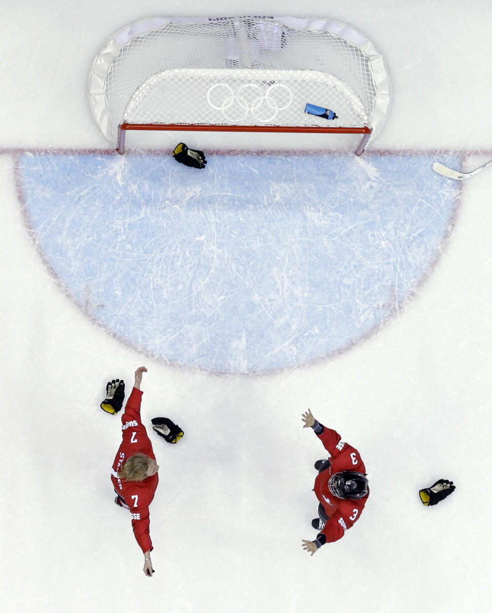 Sarah Forster of Switzerland (3) and Lara Stalder (7) react after winning the women's bronze medal ice hockey game against Sweden at the 2014 Winter Olympics, Thursday, Feb. 20, 2014, in Sochi, Russia. Switzerland won 4-3. (AP Photo/David J. Phillip )