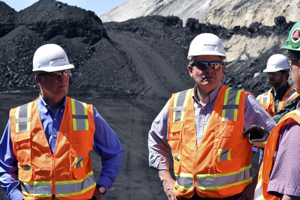 Montana Republican Gov. Greg Gianforte, left, and Republican Sen. Steve Daines listen to a Westmoreland Mining representative during a tour of the company's Rosebud mine in southeastern Montana, Tuesday, May 28, 2024, in Colstrip, Montana. Coal use has been declining in the U.S. for more than a decade. ( (AP Photo/Matthew Brown)