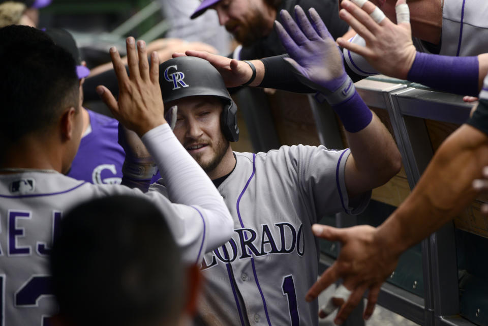 Colorado Rockies' Garrett Hampson (1) celebrates with teammates in the dugout after scoring on a Charlie Blackmon triple during the ninth inning of a baseball game against the Chicago Cubs, Saturday, Sept. 17, 2022, in Chicago. Colorado won 3-1. (AP Photo/Paul Beaty)