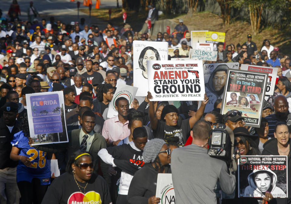 Hundreds of marchers waive their signs as they walk to the Florida Capitol Monday, March 10, 2014, for a rally in Tallahassee, Fla. Participants were rallying against the state's "Stand Your Ground" laws. (AP Photo/Phil Sears)