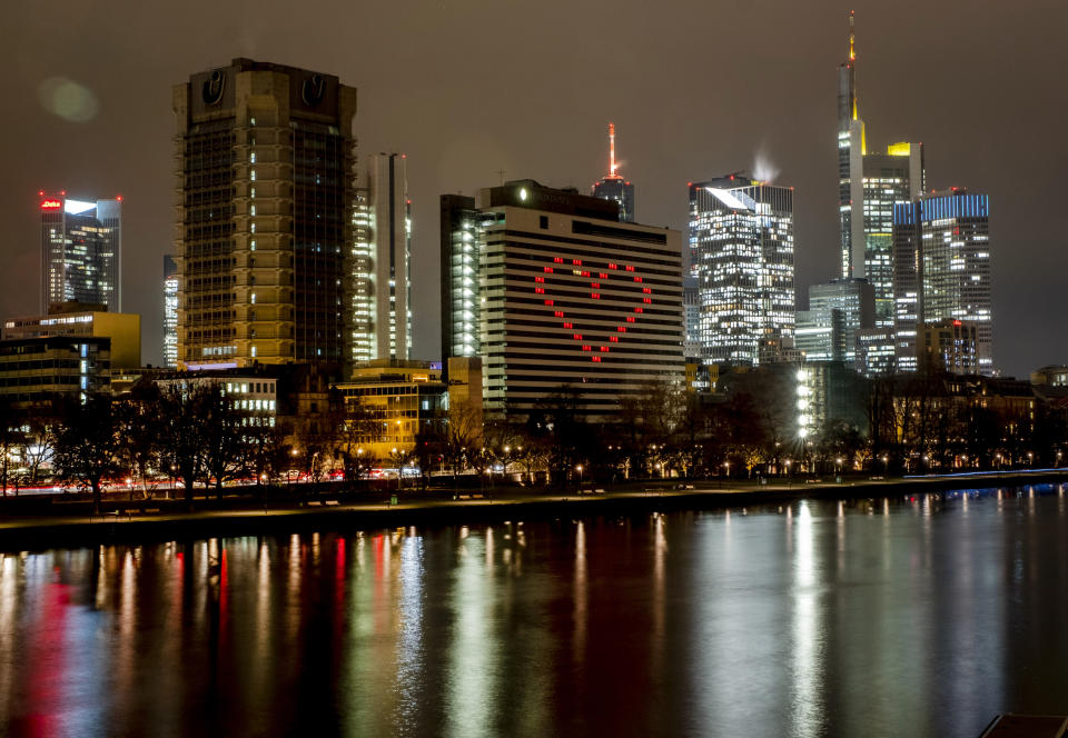 FILE - A hotel has switched on the lights in some rooms to form a heart near the buildings of the banking district in in Frankfurt, Germany, Dec. 10, 2020, as the German government discusses further restrictions to avoid the outspread of the coronavirus. Germany is set to mark 100,000 deaths from COVID-19 this week, passing a somber milestone that several of its neighbors crossed months ago but which some in Western Europe's most populous nation had hoped to avoid. (AP Photo/Michael Probst, File)