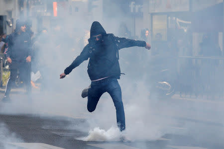 A hooded youth kicks a tear gas canister during clashes at a demonstration to protest the results of the first round of the presidential election in Paris, France, April 27, 2017. REUTERS/Gonzalo Fuentes