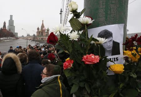 People gather at the site where Boris Nemtsov was recently murdered, with St. Basil's Cathedral and the Kremlin seen in the background, in central Moscow, February 28, 2015. REUTERS/Sergei Karpukhin