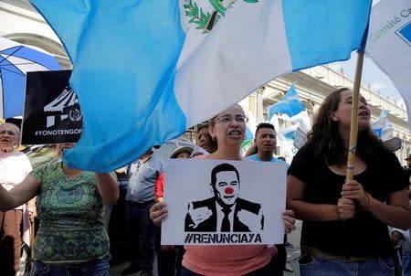 People shout slogans outside congress during a protest against Guatemala's President Jimmy Morales, in Guatemala City, Guatemala September 10, 2017. The writing on the sign reads "#resignnow." REUTERS/Luis Echeverria