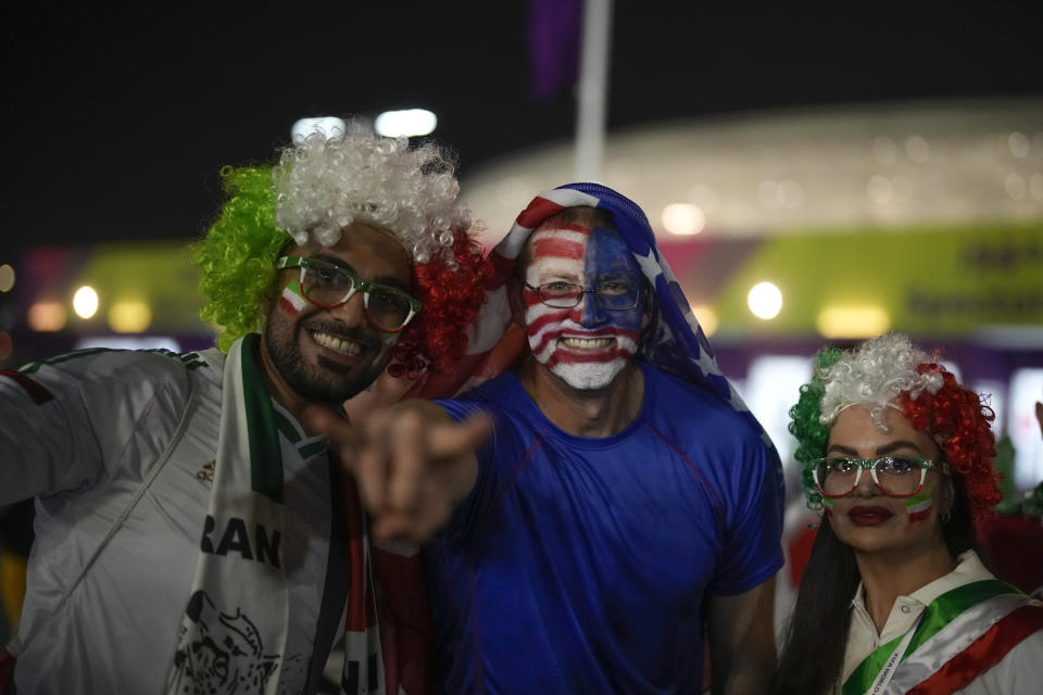 Iranian and US supporters pose for a photo before the World Cup group B soccer match between Iran and the United States at the Al Thumama Stadium in Doha, Qatar, Tuesday, Nov. 29, 2022. (AP Photo/Christophe Ena)