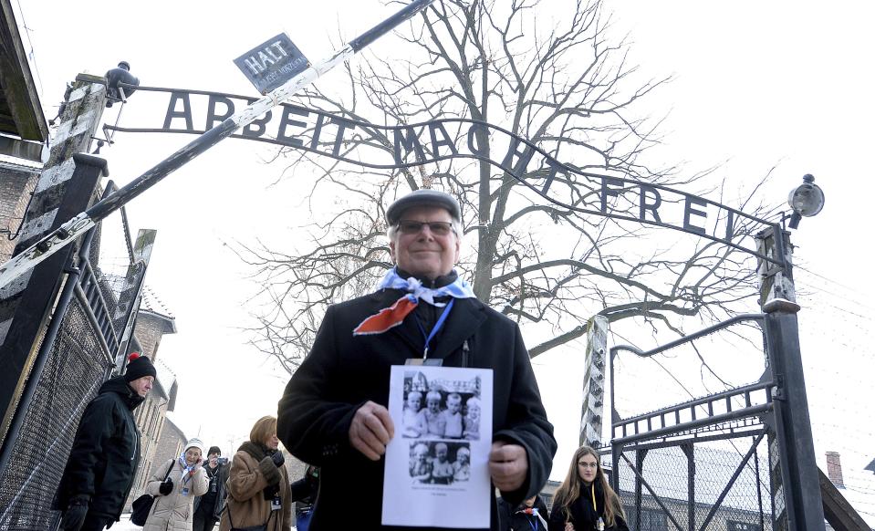 A survivor holds a poster at the former Nazi German concentration and extermination camp Auschwitz, as he attends ceremonies marking the 74th anniversary of the liberation of the camp in Oswiecim, Poland, Sunday, Jan. 27, 2019.(AP Photo/Czarek Sokolowski)