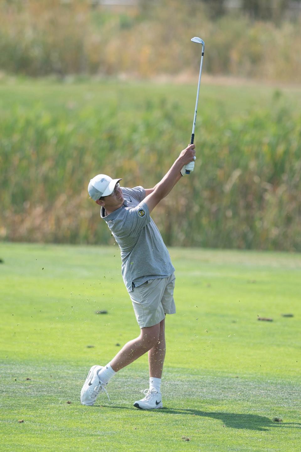 Pueblo East's Cooper Simmons hits an approach shot on the 15th hole at Walking Stick Golf Course during the state tournament on Tuesday, October 8, 2024.