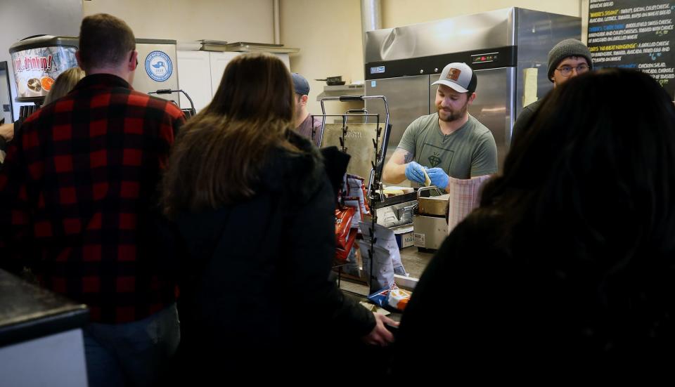 Eric Brewer fills orders for the lunch rush crowd at Diamond Deli Jan. 26 in Akron.