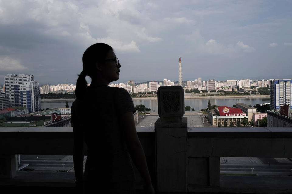 In this July 16, 2019, photo, a woman stands against the 170-meter-tall Tower of Juche Idea, center, in Pyongyang, North Korea. The word Juche is splashed across countless propaganda signs in North Korea and featured in hundreds of state media reports, and while it’s technically a political ideology, it can seem more like a religion because of its difficulty for many outsiders to grasp and ability to inspire devotion among North Koreans. (AP Photo/Vincent Yu)