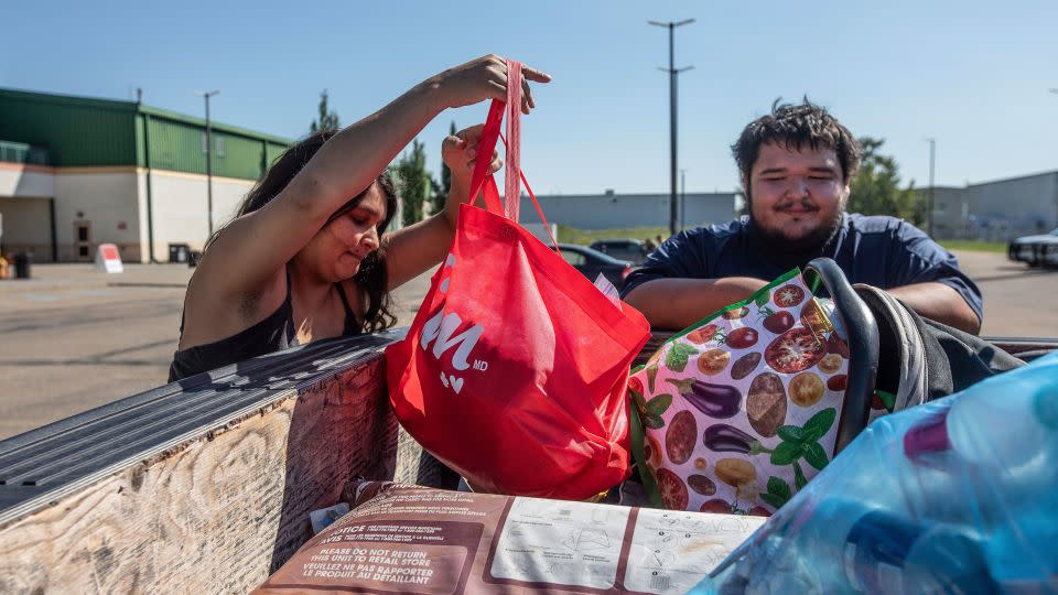 Canadian fire evacuees Tanisha Edison and her boyfriend Mason Bruneau go through their belongings at the evacuee center in St. Albert, Alberta, on August 16. - Jason Franson/The Canadian Press/AP