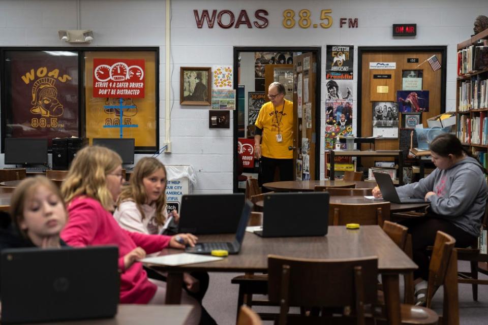 Ken Raisanen, the 69-year-old manager of WOAS 88.5-FM, stands inside the doorway leading to the student-run radio station's studio, which is located inside the school library, on Monday, April 24, 2023. 