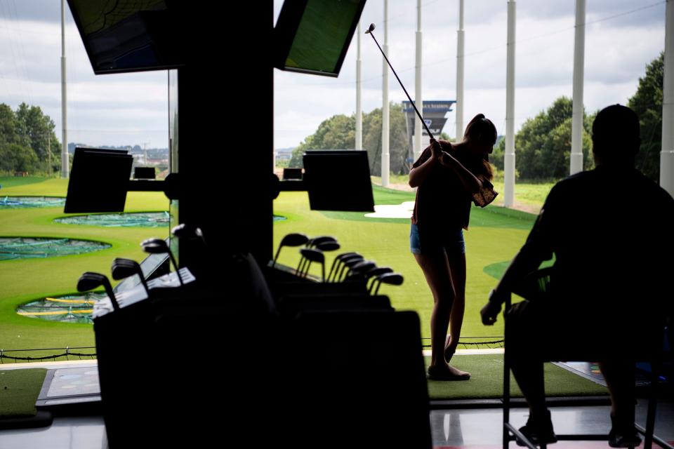 Guests take turns swinging at balls at the new Topgolf in Farragut.