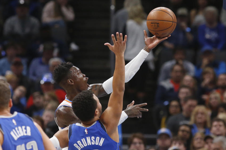 Oklahoma City Thunder guard Dennis Schroeder, rear, shoots in front of Dallas Mavericks guard Jalen Brunson during the first half of an NBA basketball game Tuesday, Dec. 31, 2019, in Oklahoma City. (AP Photo/Sue Ogrocki)