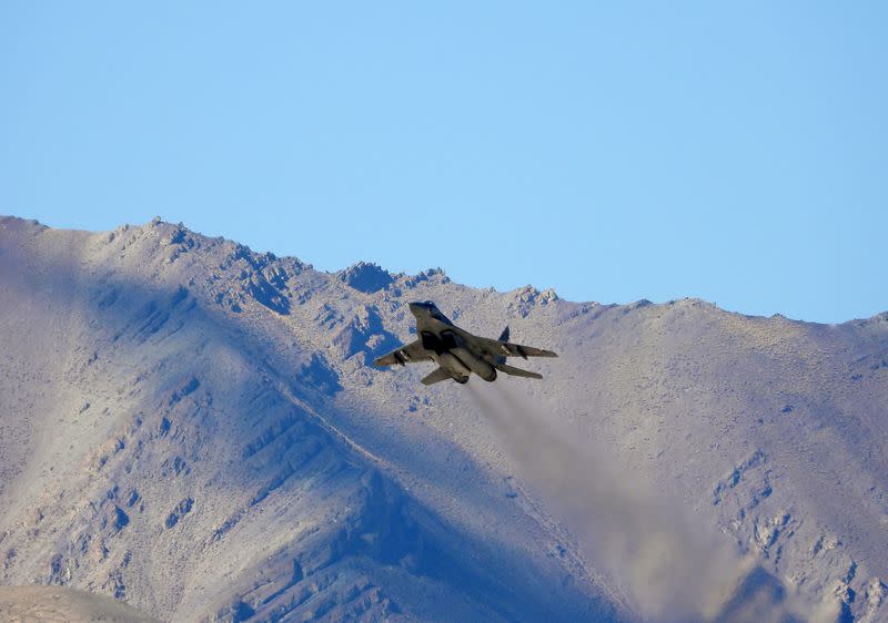 An Indian fighter plane flies over a mountain range in Leh