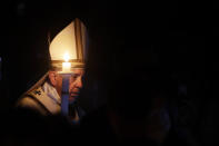 Pope Francis holds a candle as he presides over a solemn Easter vigil ceremony in St. Peter's Basilica at the Vatican, Saturday, April 21, 2019. (AP Photo/Gregorio Borgia)