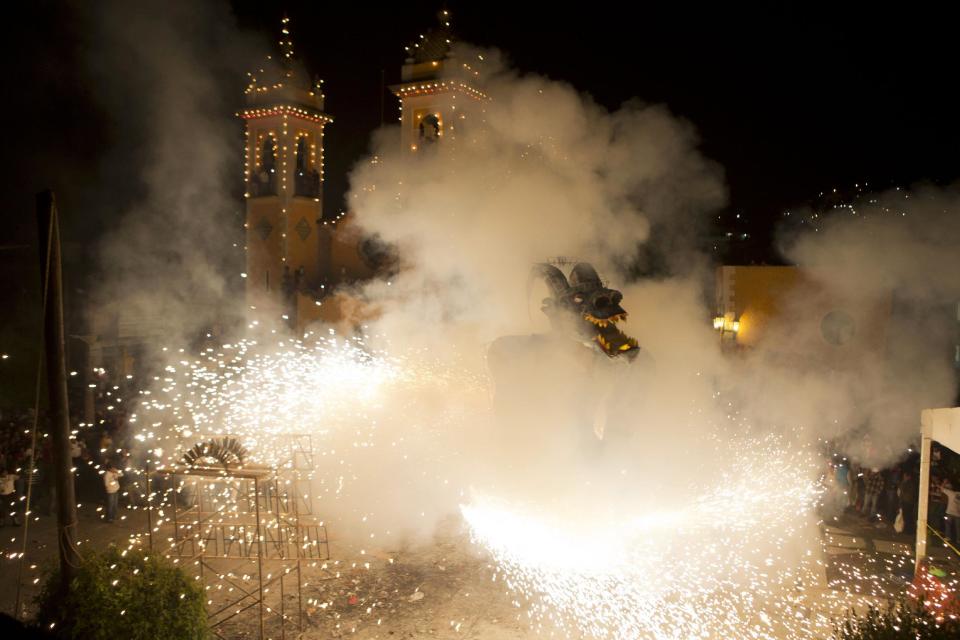 An effigy of Judas is engulfed in fireworks, in the courtyard of the Santa Rosa Xochiac church, in Mexico City, soon after midnight on Easter Sunday, April 20, 2014. The Burning of Judas is an Easter-time ritual in Santa Rosa Xochiac, where neighborhood groups build representations of Judas which are then destroyed in blazes of fireworks and small explosives. (AP Photo/Rebecca Blackwell)