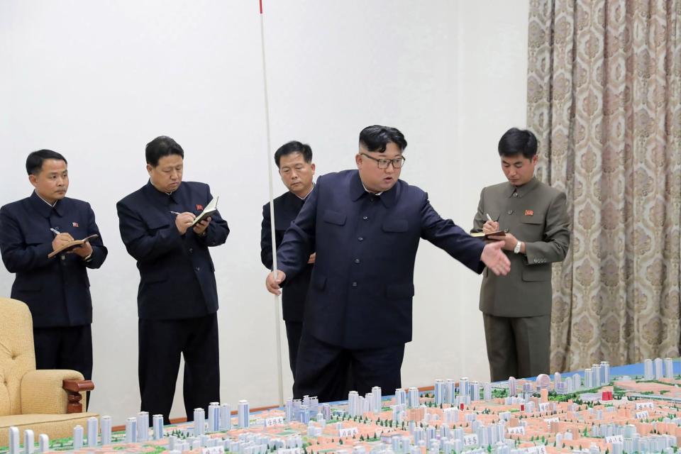 Weapons test: Kim Jong Un stands over a map with officials: AFP/Getty Images