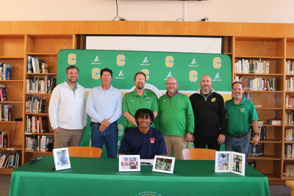 Pensacola Catholic's Chris Rembert (seated) poses for photos with Crusaders baseball coaches after signing his letter of intent to play baseball collegiately for Auburn University on Wednesday, Nov. 8, 2023 from Pensacola Catholic High School media center.