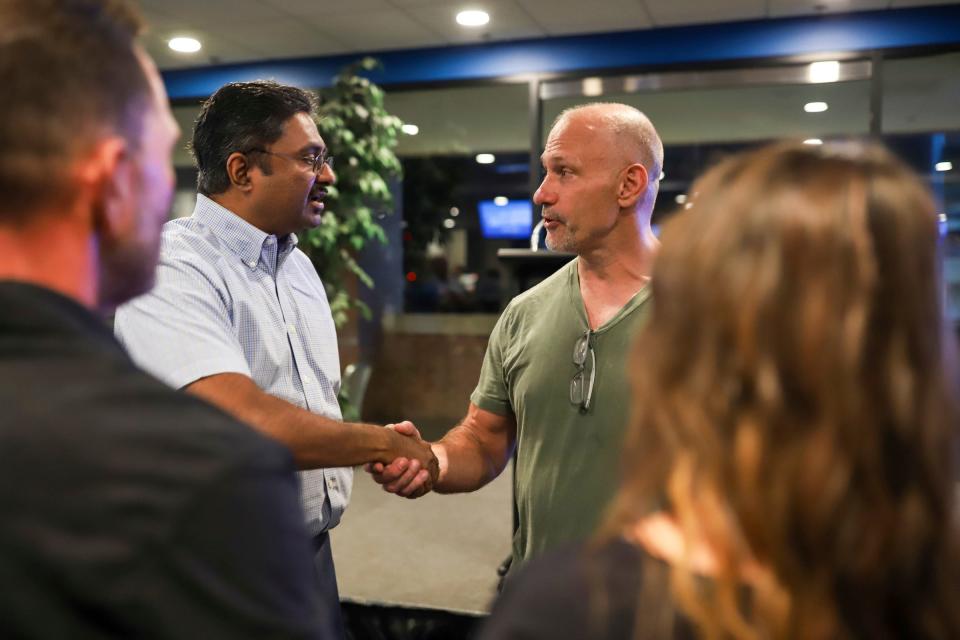 Former Detroit Lions Pro Bowl linebacker Chris Spielman shakes hands with Ram Krishnaswami, 57, of Farmington Hills telling him about his cancer journey at a Crucial Catch event at Ford Field in Detroit on Wednesday, Oct. 4, 2023. Krishnaswami says he is a Detroit Lions season ticket holder and a survivor of Stage 4 pancreatic cancer, after being diagnosed 12 years ago.